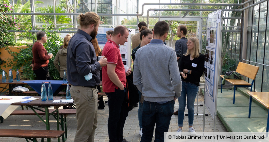 Participants of the SFB Symposium in front of a poster, © Tobias Zimmermann | Universität Osnabrück