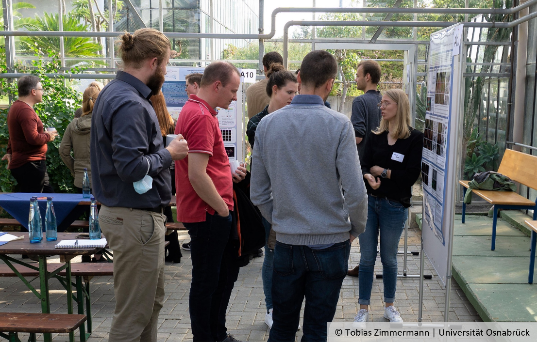 Teilnehmende des SFB-Symposiums diskutieren an einem Poster, © Tobias Zimmermann | Universität Osnabrück