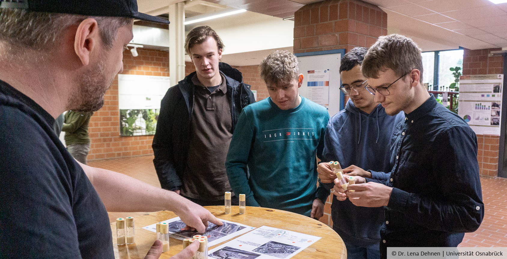 Young people hold tubes sealed with plugs in their hands.