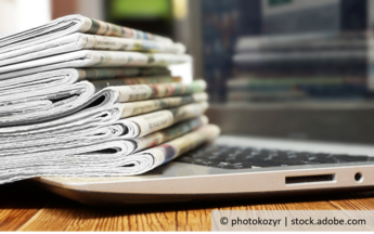 Ein Stapel Zeitungen auf einem Laptop © photokozyr | stock.adobe.com
