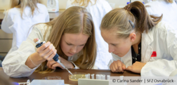 Two pupils in lab coats experimenting, © Carina Sander | SFZ Osnabrück
