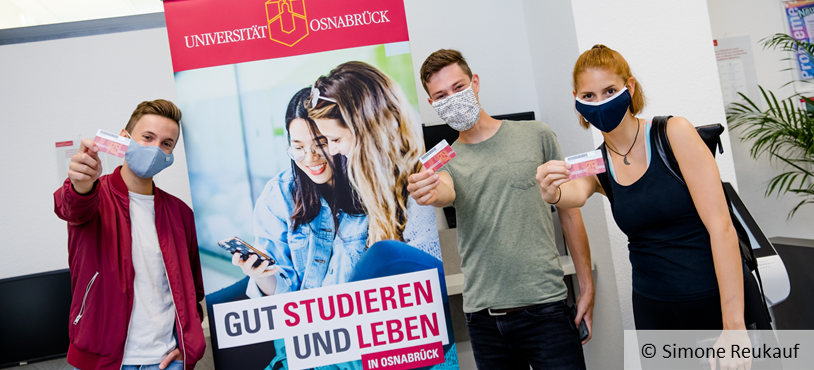 Studierende vor einem Plakat der Universität Osnabrück, © Simone Reukauf